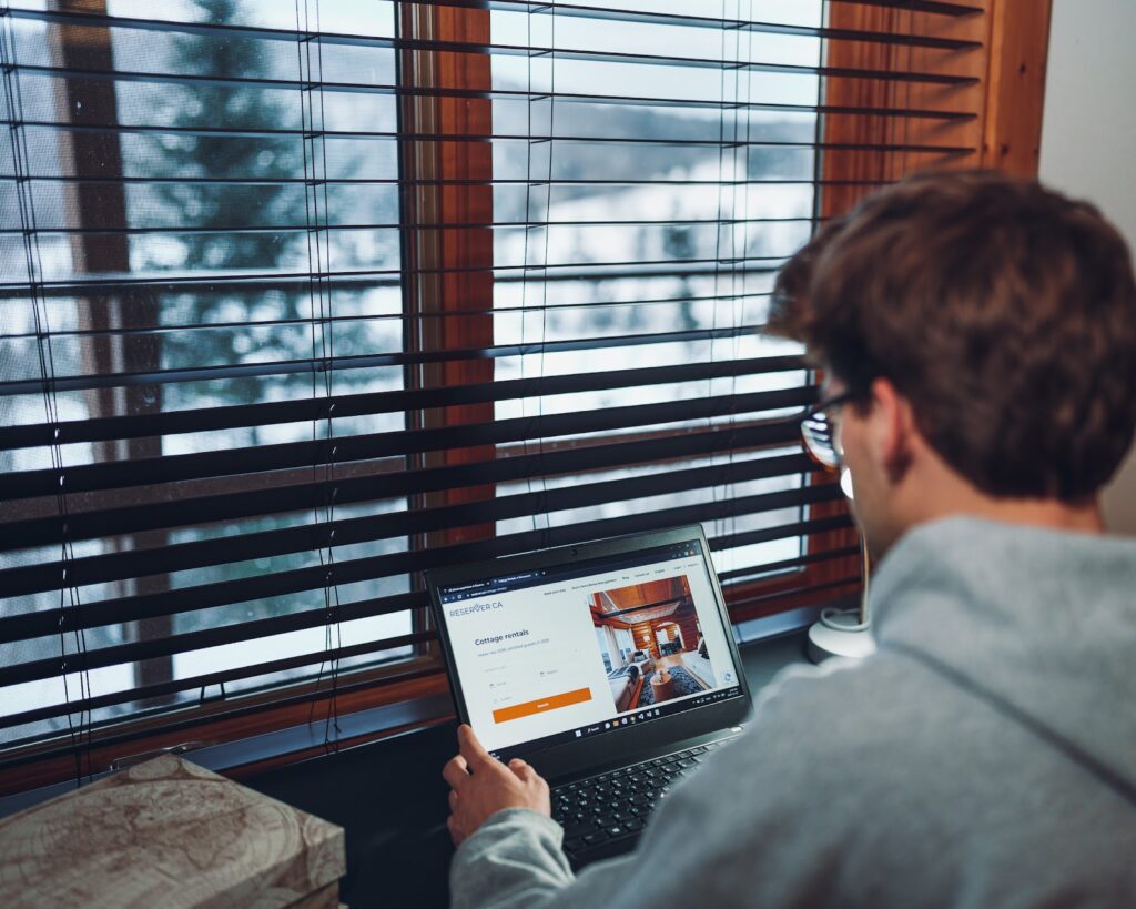 Homme feuillettant une annonce sur son laptop