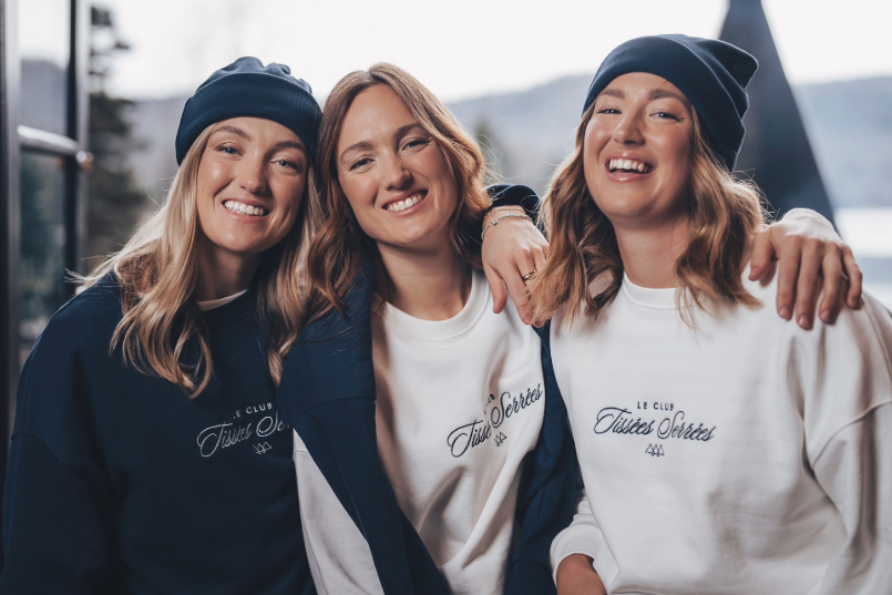 Trois filles portant des sweat-shirts d'une marque célèbre