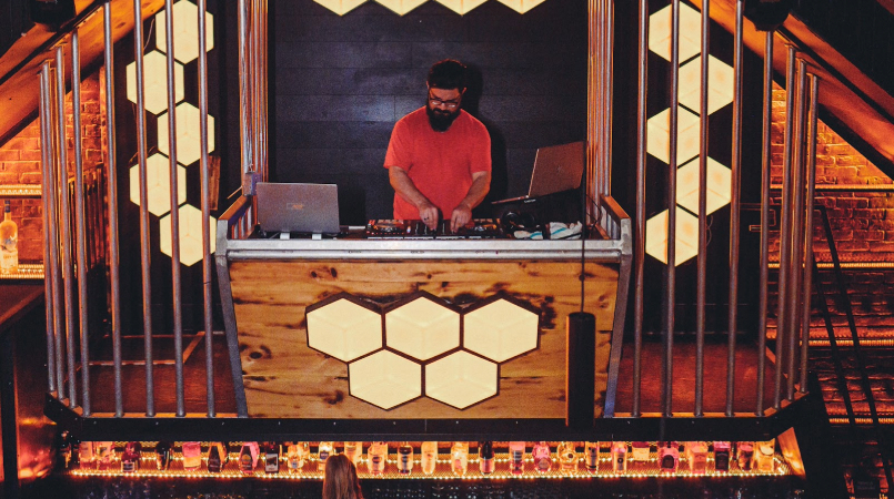 Photographie d'un dj sur sa platine dans un club