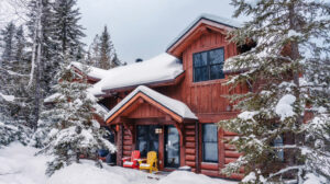 Chalet rustique entouré de neige dans les Laurentides en hiver.