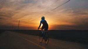 Femme faisant du vélo prise en soirée